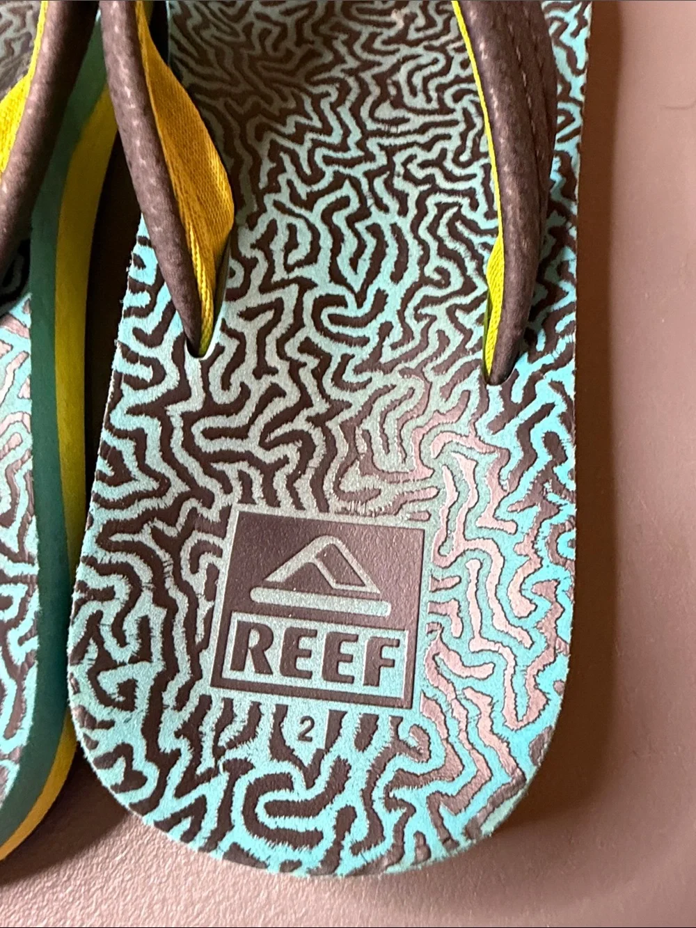 Kid’s Reef Blue & Black Patterned Flip Flops w/ yellow accent. Size: 2